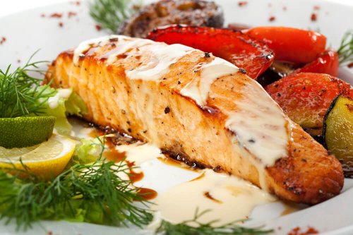 Salmon with grilled vegetables, white sauce and lemon